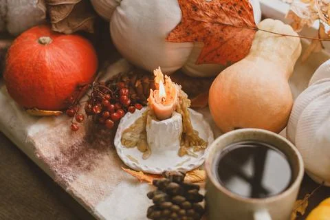 Hello fall. Warm cup of tea, pumpkins, autumn leaves, candle and woolen sca.. Stock Photos