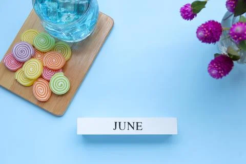 Hello June, June text on white wood block and jelly sweet on light blue Stock Photos
