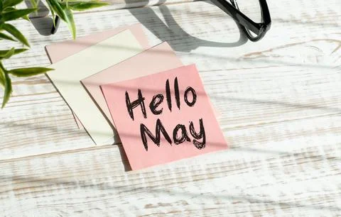 Hello May. text on white notepad paper on wooden background. Stock Photos