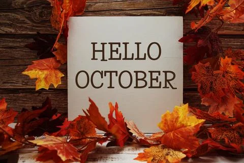 Hello October text with maple leaf decoration on wooden background Stock Photos
