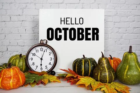 Hello October text message with pumpkin and maple leaf decoration on white br Stock Photos