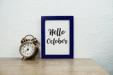 Hello October typography text and alarm clock on wooden table background Stock Photos