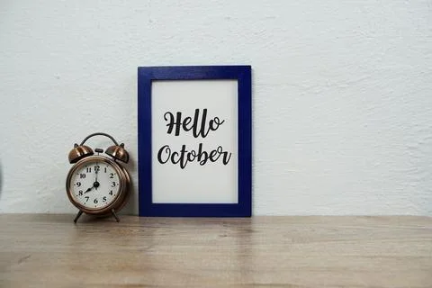 Hello October typography text and alarm clock on wooden table and white wall  Stock Photos