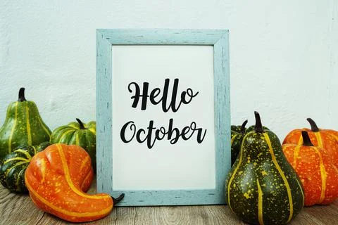Hello October typography text with pumpkin decoration on wooden table Stock Photos