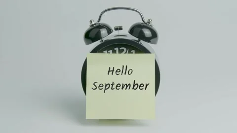 Hello September Text or Word on Yellow Note Paper Sticking onto Black Alarm Stock Footage 299534816