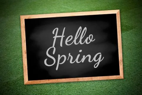 Hello spring concept on chalk board and green field background and texture Stock Photos