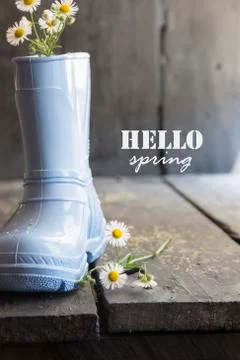 Hello spring idea, daisy and boots on a vintage table Stock Photos