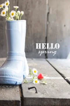 Hello spring text, daisy and boots on a vintage table Stock Photos