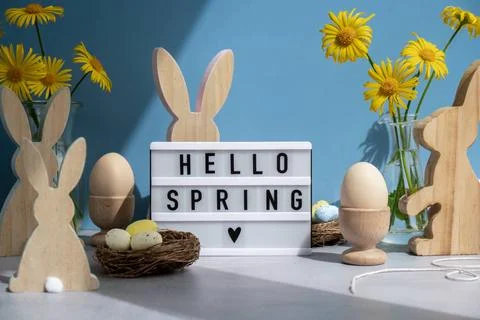HELLO SPRING text on Lightbox with bunny wooden figures eggs and fresh flo... Stock-Fotos