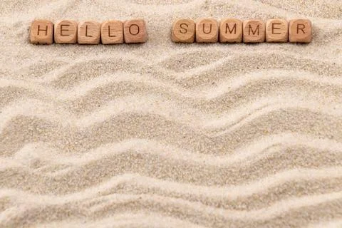 Hello summer message on sandy background with wooden blocks Stock Photos