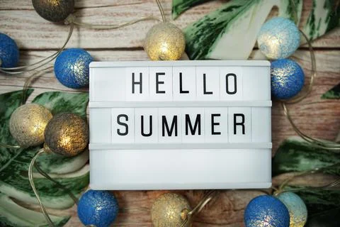 Hello Summer word in lightbox with LED cotton balls decoration on wooden back Stock-Fotos
