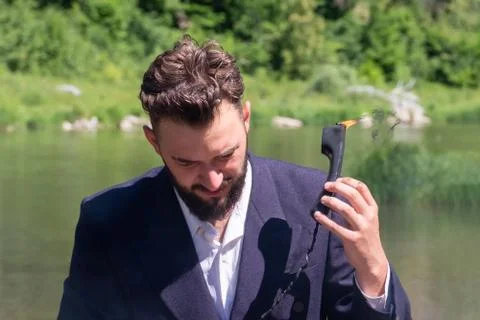 Hello, support, we have a fire. A guy in a suit holds in his hand a handset t Stock Photos
