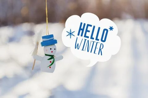 Hello winter card with speech bubble and wooden snowman toy Stock Photos