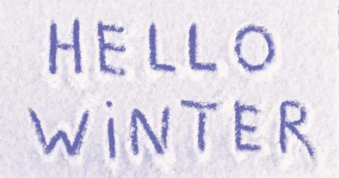 Hello Winter words written on the surface of a snow field. Stock Photos