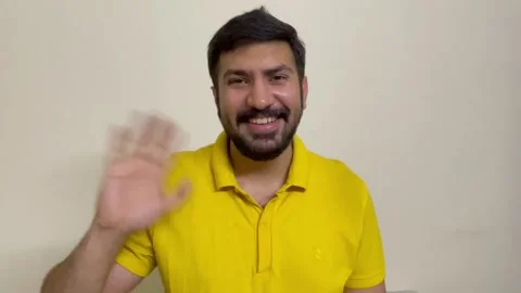 Hello. Young bearded man smiling friendly at camera, waving hands gesturing hi Stock Footage 242044846