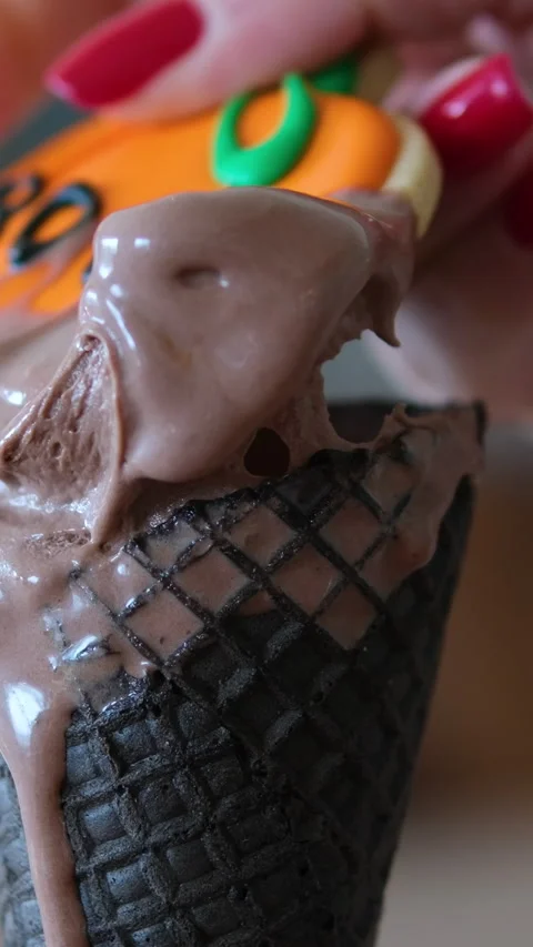 Helloween chocolate ice cream cookie pumpkin with the inscription boo eat woman Stock Footage 317703560