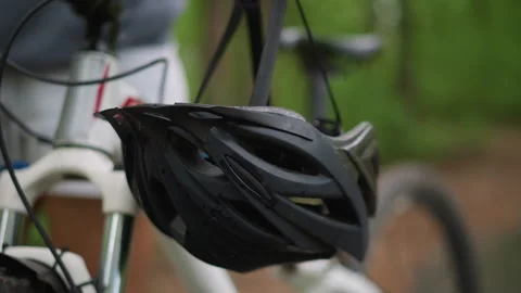 Helmet Dangling From Bike Front Fork Beside Forest Trail, White Cyclist Gear 스톡 동영상 323508080