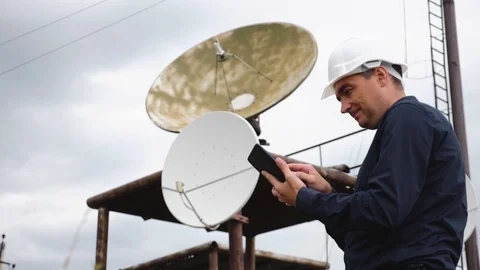 Helmet engineer and with a tablet standing on the roof of the building working Stock Footage 120059157