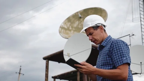 Helmet engineer and with a tablet standing on the roof of the building working Stock-Footage 121529620