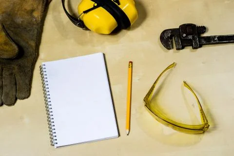 Helmet, hearing protection, tools, workshop table. Safety equipment and tools Stock Photos