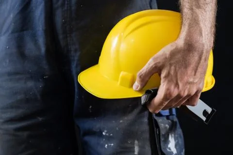 Helmet held by a construction worker. Protective clothing for manual workers. Stock Photos