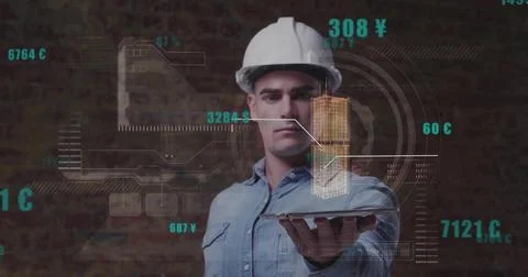 Helmeted engineer holding tablet projecting building hologram on brick wall w Foto stock