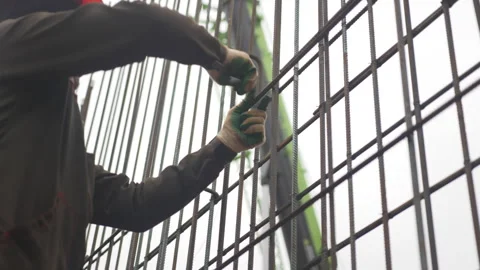 Helmeted professional secures support beam on growing frame 動画素材 311624592