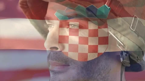 Helmeted soldier turning head at camera showing projected flag with checkered Stock Footage 330344797
