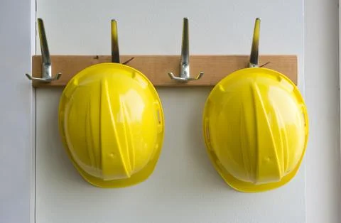 Helmets on coat hangers Stock Photos