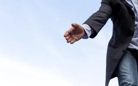 Help concept hand reaching out to help someone with blue sky Stock Photos