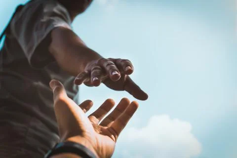 Help Concept hands reaching out to help each other in dark tone. Stock Photos