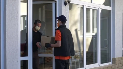 Help during COVID-19: Volunteer, Donate, or Provide Services. A courier in mask Stock Footage 129126496