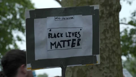 A help stop racism Black Lives Matter placard in Hyde Park, London Stock Footage 131995698