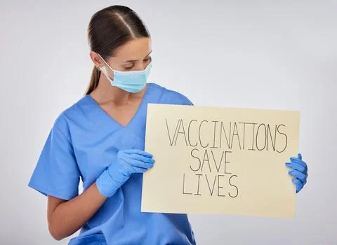 Help us save lives. a young female nurse holding vaccination signage against a Stock Photos
