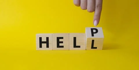 Help vs Hell symbol. Businessman hand points at turned wooden cube with wor.. Stock Photos