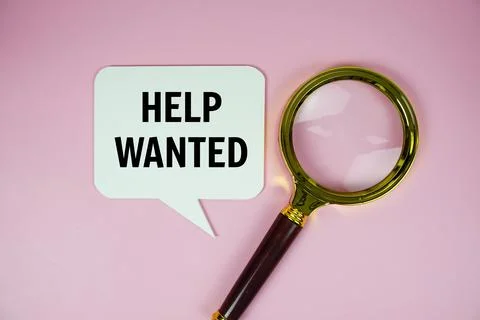 Help Wanted text on speech bubble with magnifying glass top view on pink ba.. Stock Photos