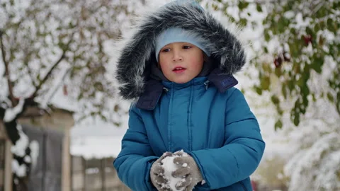 A helper in the heart of winter, a kid faces the storm's fury, shoveling snow to Stock Footage 267278149