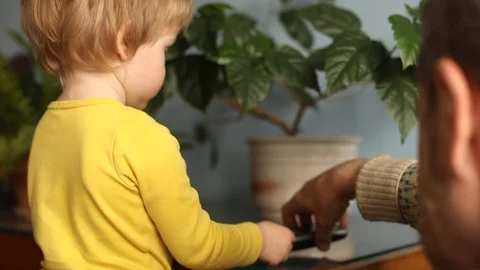 Helpful granddaddy learning little boy to use phone smartphone cellphone 스톡 동영상 112773567