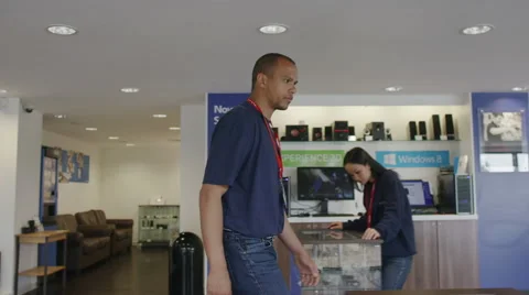 Helpful team of staff at work in modern consumer electronics store showroom Stock Footage