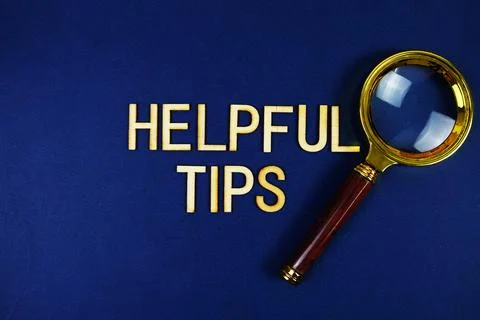 Helpful Tips alphabet letters with magnifying glass on navy blue background Stock Photos