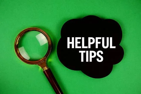 Helpful Tips text with speech bubble and magnifying glass on green background Stock Photos