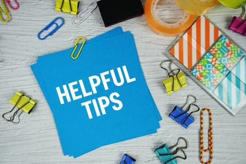 Helpful Tips text on stick note with stationery on concrete background Stock Photos