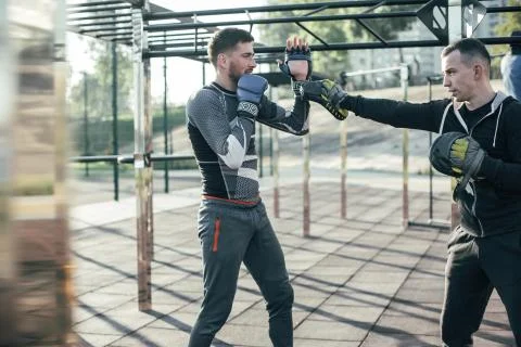Helpful trainer talking to the boxer while wearing focus mitts Stock Photos