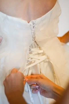 Helping the bride to put her wedding dress on Stock Photos
