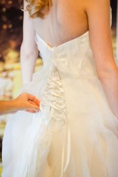 Helping the bride to put her wedding dress on Stock Photos