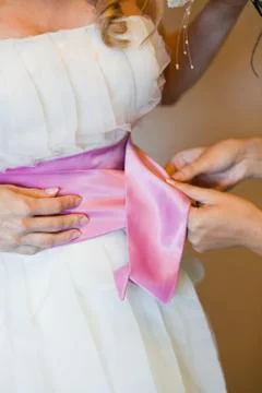 Helping the bride to put her wedding dress on Stock Photos