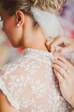 Helping the bride to put her wedding dress on Stock Photos