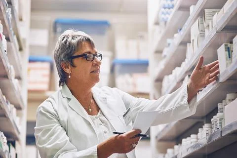 Helping patients to maintain and optimize their health. Shot of a pharmacist at Stock Photos
