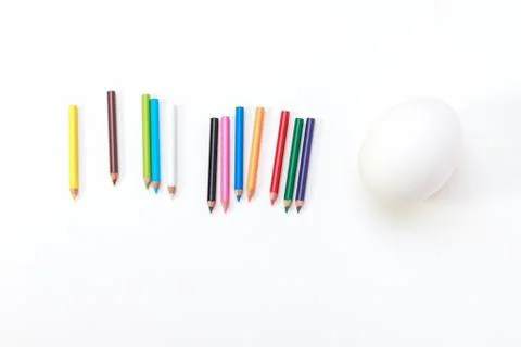 A hen egg with twelve crayons Stock Photos
