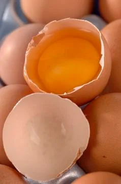 Hen eggs, one broken, lying on the table Stock Photos